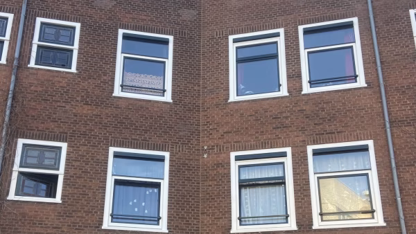 Vooraanzicht bakstenen gevel aan de Witte de Withstraat in Amsterdam, vóór reiniging van de gevel.
